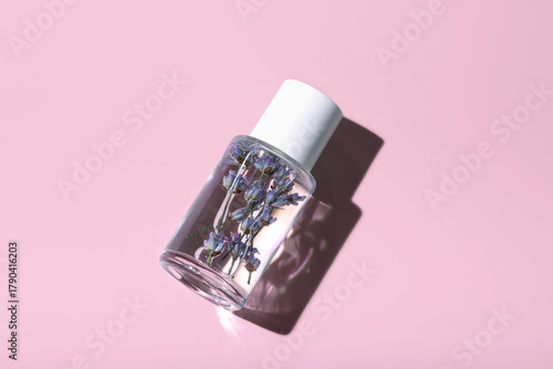 Glass bottle with lavender tonic on pastel pink background. Skin care. Eco friendly zero waste.