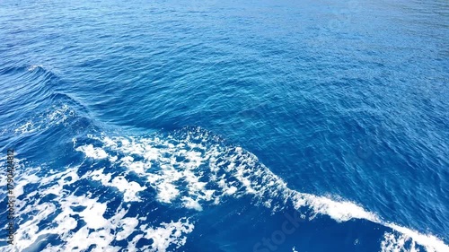 Waves on the surface of the blue sea from the movement of a boat