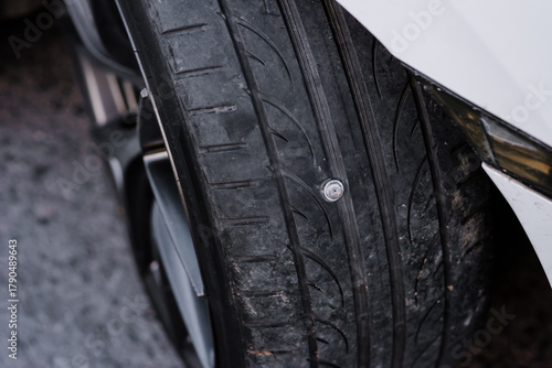 A tire has been punctured by a nail and is now flat, making it impossible to drive further.This could cause further damage to the tire.Therefore,it must be repaired before it can be put back into use.