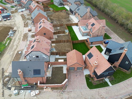 Aerial view of a near completed British housing estate of both first time and detached luxury family homes. Top soil can be seen laid to some of the houses back gardens.
