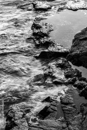 Monochrome Waves Crashing on Rocky Shore