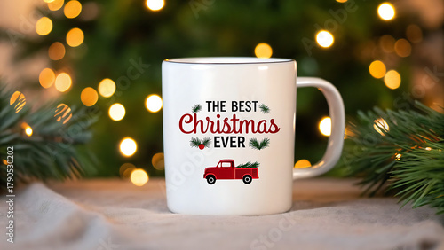 White ceramic mug with the best christmas ever text and red truck graphic on a festive blurred background with christmas tree and lights