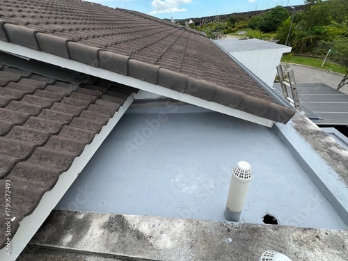 Bild auf Leinwand Waterproofed flat roof beside tile roof with vent pipe