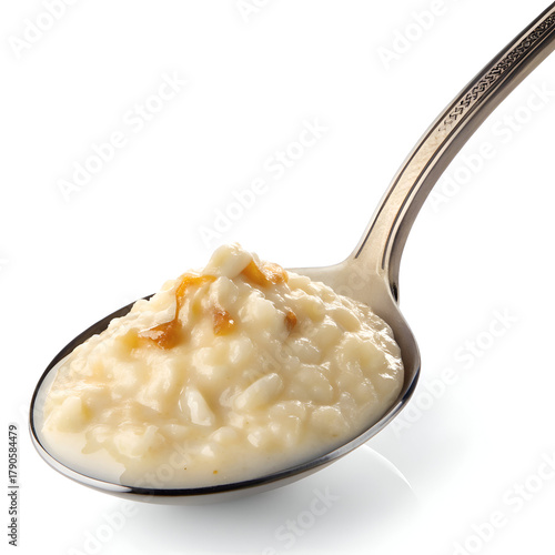 A close up shot of a spoonful of creamy rice pudding with caramel drizzle on a white background