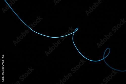 Minimalist abstract background with a single glowing blue neon line on a pure black backdrop. Simple futuristic design element. Blue laser abstract matrix background 