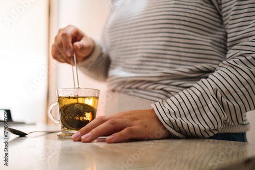 Brewing tea in a glass cup at home kitchen counter