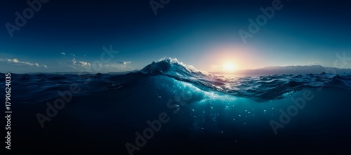 Fototapeta Naklejka Na Ścianę i Meble -  Beautiful blue ocean with a wave and a sun in the sky. The sun is setting and the water is calm