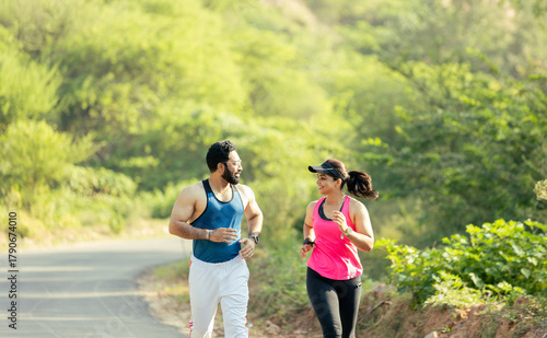 Fit Indian Couple Running Together Outdoors on a Scenic Road