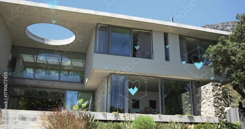 Displaying two-story concrete-glass house jutting over patio on slope, with skylight and blue icons