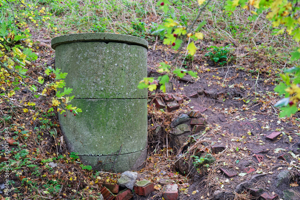 Obraz premium Old concrete ventilation shaft surrounded by autumn nature showing decay and infrastructure history