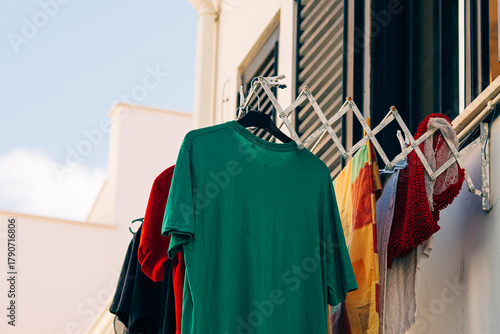 Fotografie Colorful clothes drying on balcony rack