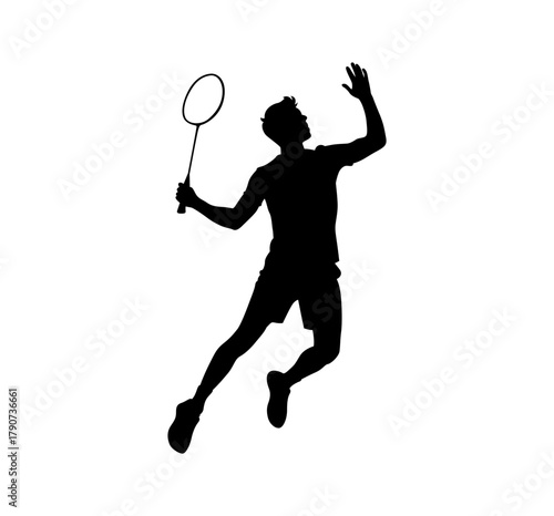 Silhouette of a male badminton player in action jumping to hit the shuttlecock with a racket