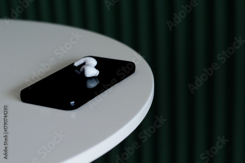 Obraz na plátně Smartphones and wireless headphones are placed on the leisure lifestyle table