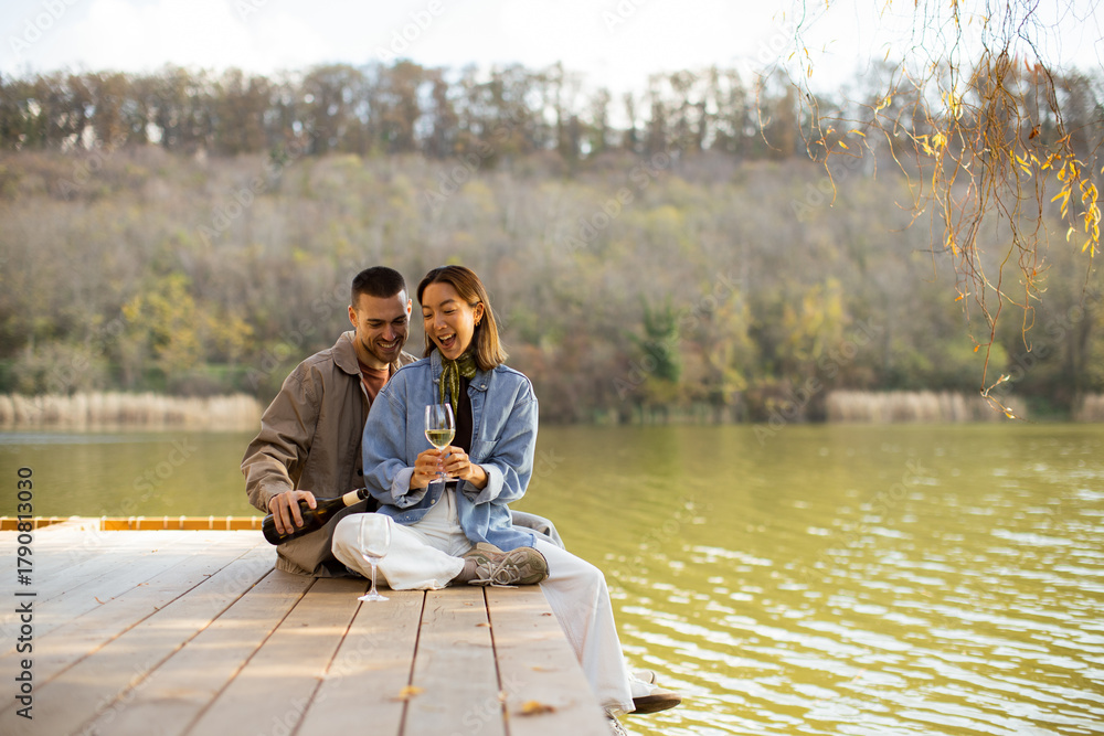 Naklejka premium Couple enjoys a romantic moment by the serene lake during a sunny afternoon