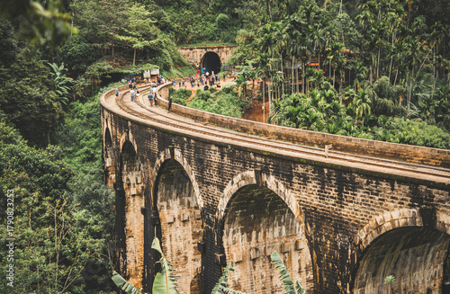 Nine arches bridge in tropical jungle with tourists walking on railway, Ella, Sri-Lanka