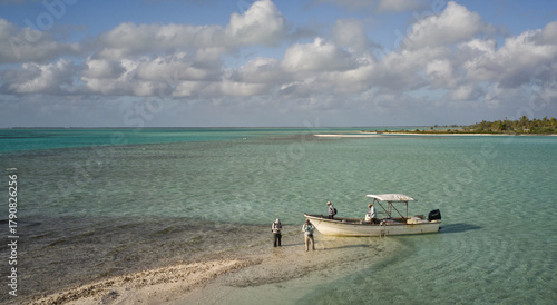 ly fisherman preparing to wade the shallow tropical flats beside a skiff on Kiritimati (Christmas Island), Kiribati. The crystal-clear turquoise waters and pristine Pacific coastline make this world-f