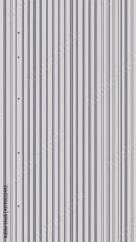 A full frame shot of a gray metal wall with vertical lines and some holes on the left side of it