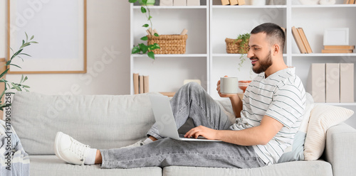 Young man with coffee using...