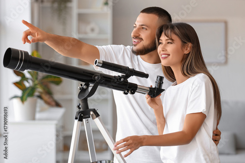 Young couple with telescope...
