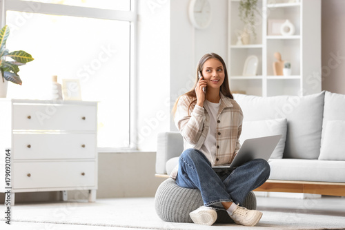Young woman with laptop tal...