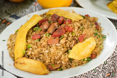 Close up of Arroz Chaufa Amazonico, a Peruvian jungle-style fried rice. This dish includes cecina (cured meat), chorizo, and fried plantain slices. Traditional fusion food from Peru.