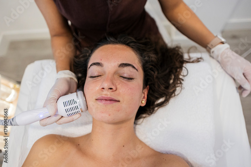 Woman receiving facial skincare treatment in beauty salon