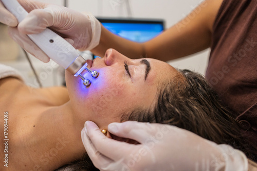 Woman receiving microcurrent facial treatment for skin rejuvenation