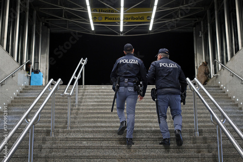 Two uniformed police officers climb the stairs leading outside the Central Station.