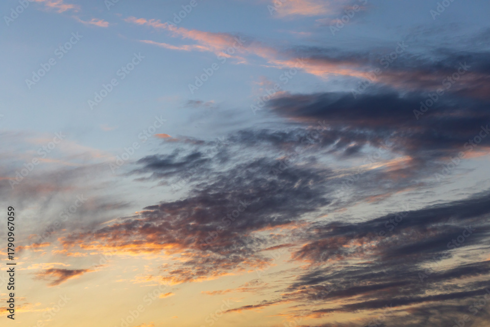 Naklejka premium The sky is filled with clouds and the sun is setting