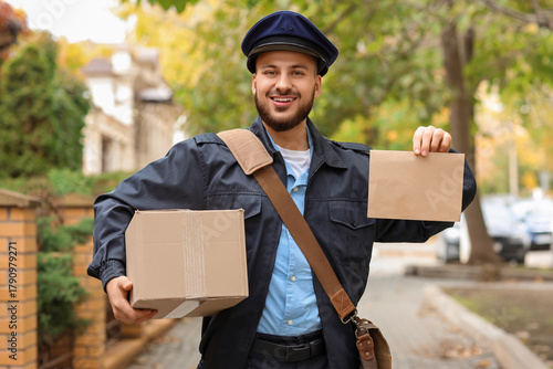 Smiling mailman delivering ...
