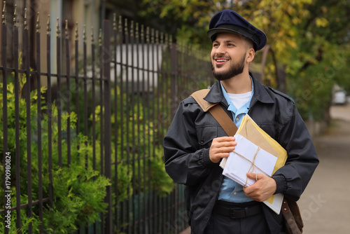 Handsome postman with lette...