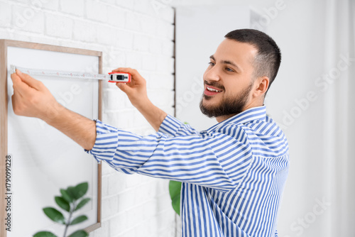 Young man measuring blank f...