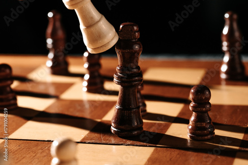 Vászonkép Tight close-up as a white piece strikes the dark king; crisp light and bold shadows freeze the decisive moment of capture on the chessboard