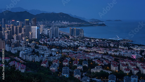 Photos Qingdao City Skyline at Dusk with Coastal Mountains and Illuminated Buildings