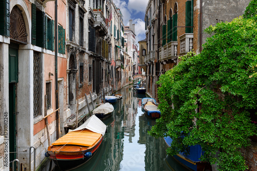 Narrow canal with boats in Venice, Italy. Architecture and landmark of Venice. Cozy cityscape of Venice.
