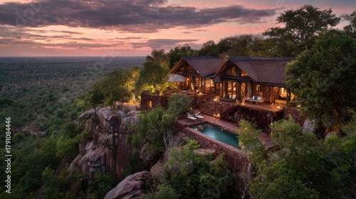 Wallpaper Mural A large house with a pool and a view of the mountains. The house is surrounded by trees and the sky is orange and pink Torontodigital.ca