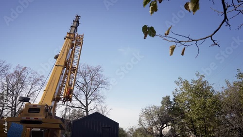 The truck crane lowers its boom.