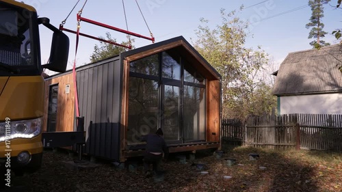 A worker checks the fit of the house's base to the foundation.