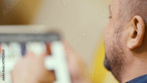 Man chooses film or Tv show to watch on an online steaming service app at home.