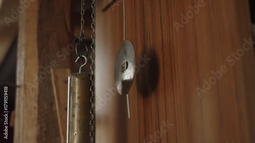 The pendulum of an old clock is swinging