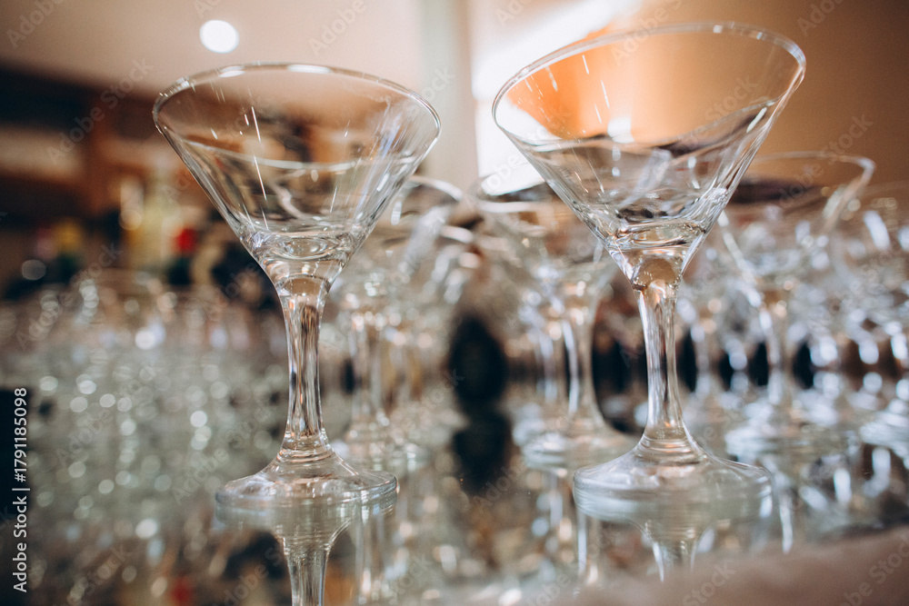 Obraz premium Empty martini glasses on a reflective surface preparing for an event