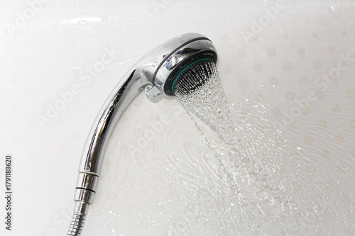Chrome Shower Head Spraying Water on White Background