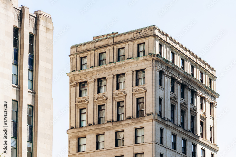 Fototapeta premium Montreal, Canada - August 11, 2025: Historic State Street Building next to Aldred Building on Place d'Armes in Old Montreal with classic architectural details