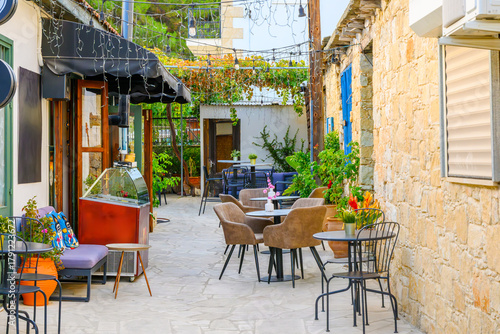 Fototapeta Naklejka Na Ścianę i Meble -  A small outdoor cafe patio in the historic medieval mountain town of Omodos, in the Troödos Mountains of the Limassol District on the Mediterranean island of Cyprus.