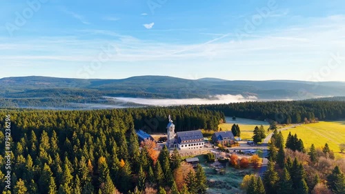 Discover the beauty of Kralovka lookout tower surrounded by colorful autumn trees in the Jizera Mountains. Enjoy stunning aerial views of nature and majestic forest landscapes.