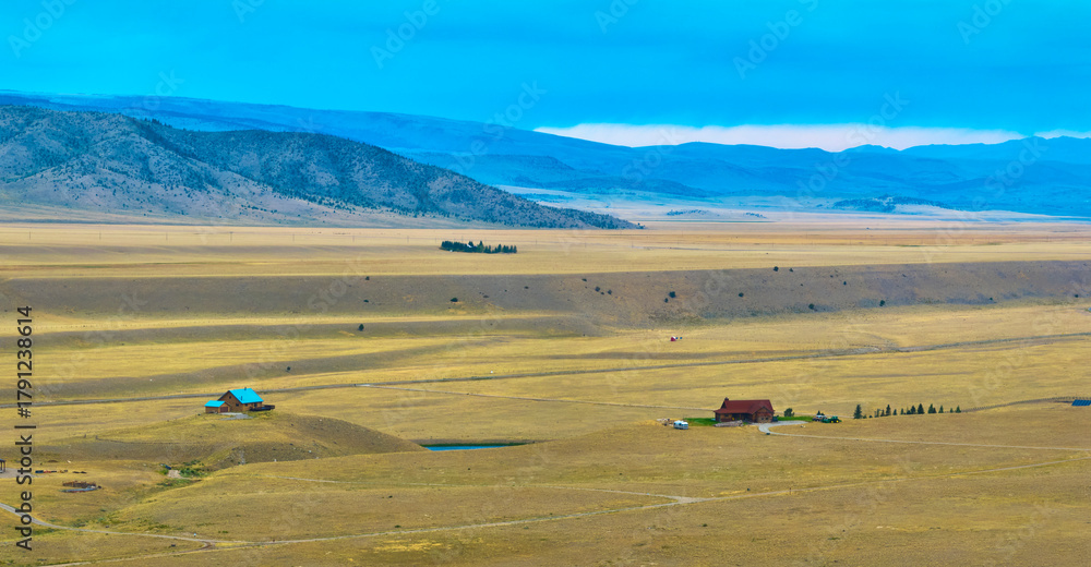 Obraz premium Aerial Wyoming Ranch Houses Expansive Plains and Distant Mountain Panorama