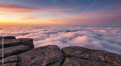 Dramatic rocky ledge extends into a vast, expansive sky filled with soft, colorful clouds, offering a breathtaking natural view ,open ,mountain ,natural beauty