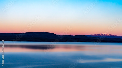 Stunning vibrant reflections of the sky and mountains on Lake Pukaki at sunset