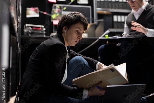 Wallpaper Mural Woman investigator sitting on the floor and searching case files for clues, working hard with the senior chief of police to solve organized crime activity. Reviewing forensic evidence. Torontodigital.ca