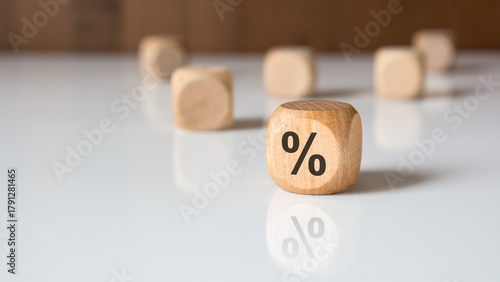 Wooden block with percent symbol on white table symbolizing interest rate and finance.